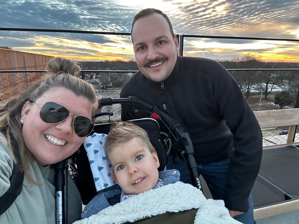 Familie Kradolfer lacht in die Kamera, ein Sonnenuntergang im Hintergrund.