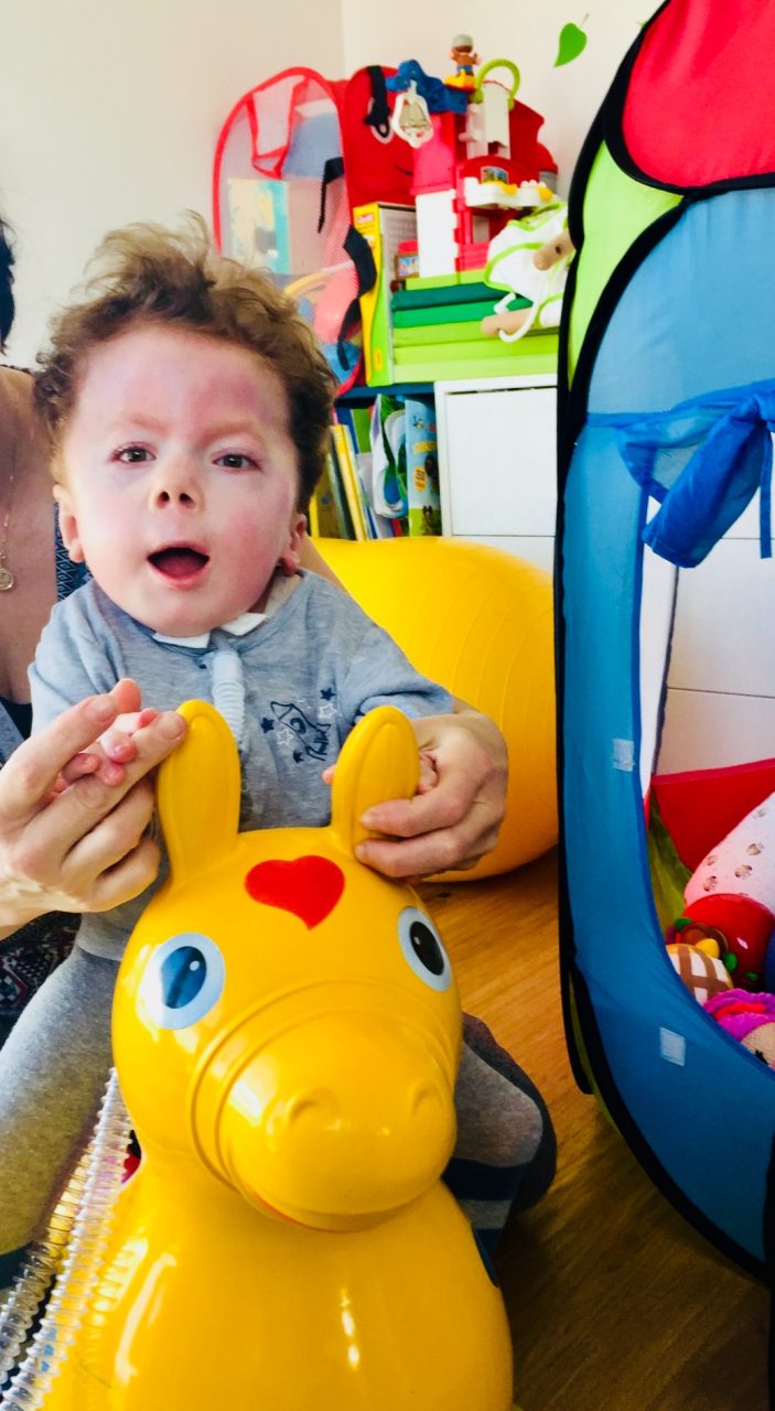 Constantin auf einem Spielzeugpferd war ein glücklicher Junge auch mit der Diagnose RYR1.